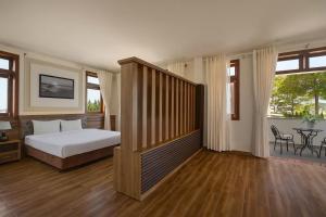 a bedroom with a bed and a table and windows at Moon Valley Villas Đà Lạt in Xuan An +102 photos