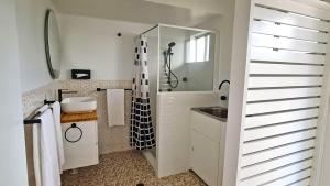 a bathroom with a sink and a shower at 85 on First - Sawtell Apartments in Sawtell