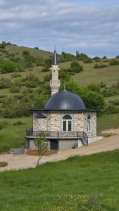 a building with a clock tower on top of a hill at Adventure Camping Kosovo in Prizren +3 photos