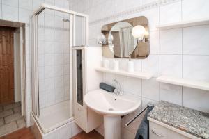 a white bathroom with a sink and a shower at Ferienwohnungen Traumschloss in Wernigerode +48 photos