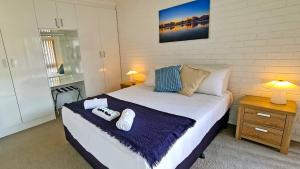 a bedroom with a bed with two remote controls on it at 85 on First - Sawtell Apartments in Sawtell