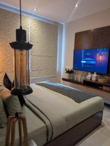 a bedroom with a large bed with a flat screen tv at The Green Door in Ella