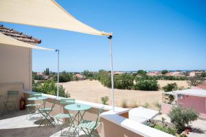 a balcony with tables and chairs and a view of a field at Olia's Rooms in Skala Eresou