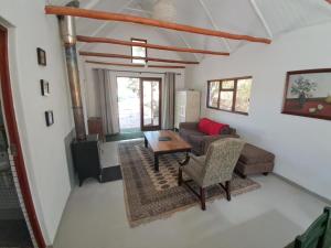 a living room with a couch and a table at Kleinwatervalplaas Farm Stay Accomodation in Caledon