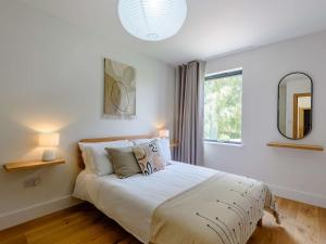 a white bedroom with a bed with a large window at 3 Bed in Ludlow 83865 in Lane to Richards Castle