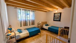 a room with two beds and a crib in it at La Ferme du Bonheur in Aspres-sur-Buëch