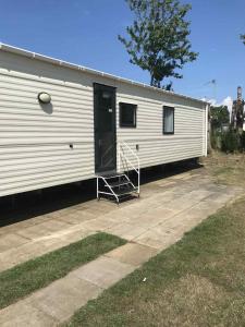 a white trailer with a door and a ramp at Luxury 2 bedroom Caravan Pets stay Free in Hunstanton