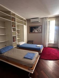 a bedroom with two beds and a book shelf at Pace Blu Roma in Rome