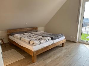 un grand lit dans une chambre avec une fenêtre dans l'établissement Feriennest am Wangermeer, à Wangerland