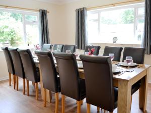 a conference room with a wooden table and chairs at Blackmoor Farmhouse in Stepaside