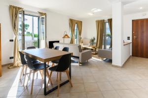 a dining room and living room with a table and chairs at Villa Nymphaea Sperlongaresort in Sperlonga