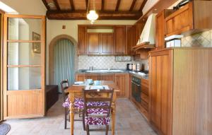 a kitchen with wooden cabinets and a table with chairs at 2 Bedroom Stunning Home In Casacastalda in Casa Castalda