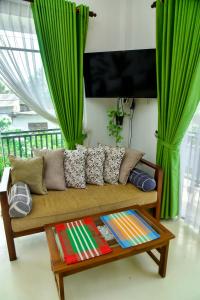 a couch in a living room with green curtains at Villa Green Smile in Aluthgama