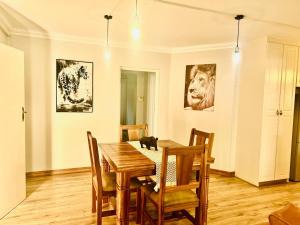 a dining room with a table and a cat sitting on the floor at Big 5 Cottage in Pretoria +11 photos