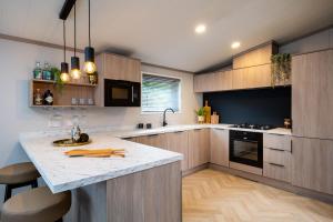 セント・アンドルーズにあるHot tub Lodge, Victory 101の木製キャビネットと広いキッチンアイランド付きのキッチン