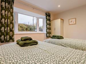 two twin beds in a room with a window at 3 Bed in Threlkeld 93589 in Threlkeld