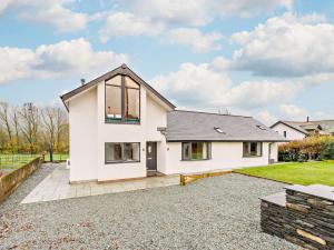 a white house with a gravel driveway at 3 Bed in Threlkeld 93589 in Threlkeld