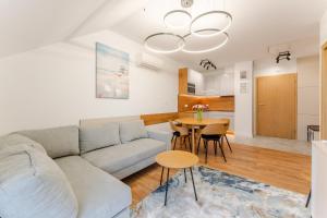 a living room with a couch and a table at Sunday Resort Ustronie Morskie in Ustronie Morskie