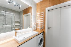 a bathroom with a sink and a washing machine at Sunday Resort Ustronie Morskie in Ustronie Morskie +95 photos