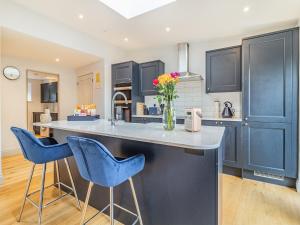 a kitchen with blue chairs and a counter top at The Old Barn in Mundesley