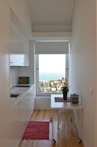 a kitchen with a table and a view of the ocean at Aldeia do Priolo in Nordeste