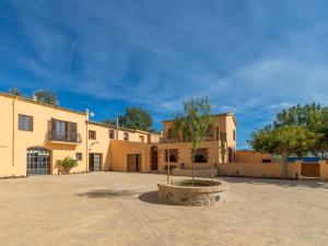 un gran edificio con un árbol en un patio en Mas Mare de la Font para 25 personas /1095, en Castelló d'Empúries