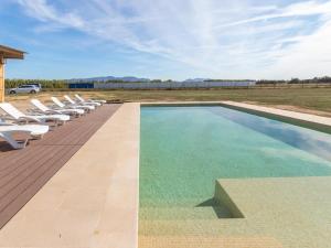 una piscina con tumbonas junto a un campo en Mas Mare de la Font para 25 personas /1095, en Castelló d'Empúries