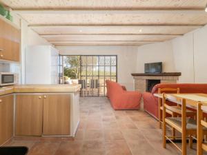 Una cocina y una sala de estar con un sofá y una mesa. en Mas Mare de la Font para 25 personas /1095, en Castelló d'Empúries