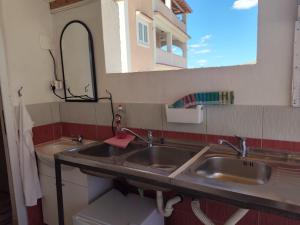 a bathroom with two sinks and a mirror at Caravan with private toilet and kitchen 2 in Grebaštica