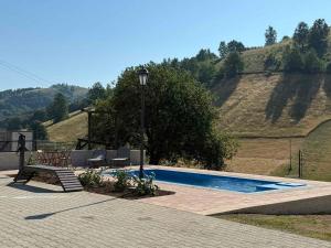 a swimming pool with two chairs and a light pole at Villa Mramor in Brzeće