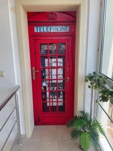 a red door with a telephone sign on it at Apartment Siana in Balchik