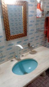 uma casa de banho com um lavatório azul e um espelho. em 3 Quartos sobrado VINTAGE em Uberlândia mais 36 fotografias