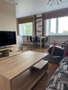 Una sala de estar con un televisor y una mesa. en Grau Apartments 26, en Pärnu
