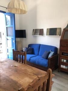 a living room with a blue couch and a table at Casa Marietta in San Vito lo Capo