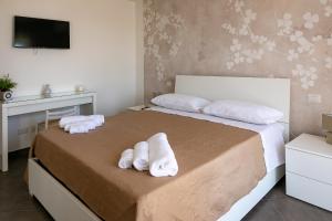a bedroom with two white towels on a bed at Mare Blu in Giardini Naxos