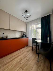 a kitchen with a table and a dining room at Квартира - Терракота in Ustʼ-Kamenogorsk