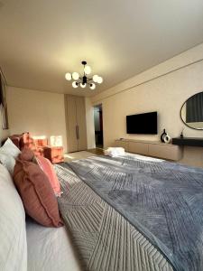 a bedroom with a large bed and a flat screen tv at Квартира - Терракота in Ustʼ-Kamenogorsk