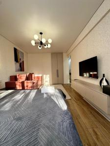 a living room with a large bed and a television at Квартира - Терракота in Ustʼ-Kamenogorsk