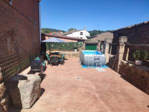 d'une terrasse avec un bain à remous, des tables et des chaises. dans l'établissement Casa rural Regajo Lobos, à San Bartolomé de Béjar