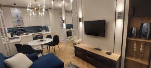 Una sala de estar con un sofá azul y un televisor. en Apartment 20 minutes from Warsaw with Balcony by Noclegi Renters, en Ożarów Mazowiecki