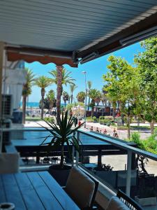 a patio with a bench and palm trees and a bridge at Apartman Leoni 1 linea in Salou
