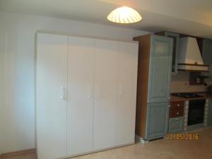 una cocina con un gran armario blanco en una habitación en Debora en Roncegno