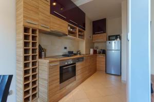 a kitchen with wooden cabinets and a refrigerator at Belgrade Central QUINCE Apartment in Belgrade