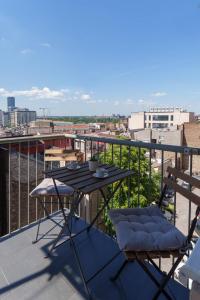 a table and chairs on a balcony with a view at Belgrade Central QUINCE Apartment in Belgrade