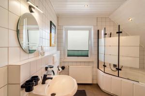 un bagno con lavandino e specchio di Ferienwohnung an der Ohme a Warburg Altre 29 foto