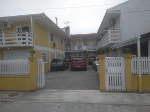 a row of houses with cars parked in a parking lot at Pousada belas ilhas in Balneario Barra do Sul