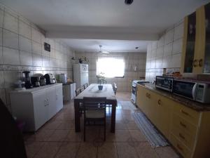 a kitchen with a table and a small table in it at Pousada belas ilhas in Balneario Barra do Sul