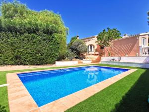 a swimming pool in the yard of a house at Villa Tossalet VYB in El Tosalet
