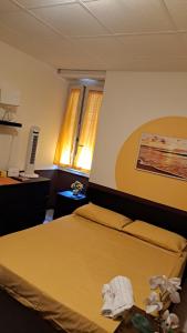 a bedroom with a bed with a yellow bedspread at Sant Antonino Metro Pozzo Strada in Turin