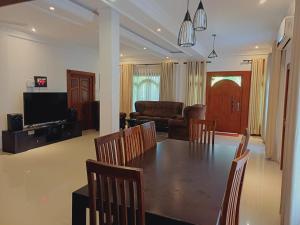 a dining room and living room with a table and chairs at JarushanInnHotel in Jaffna